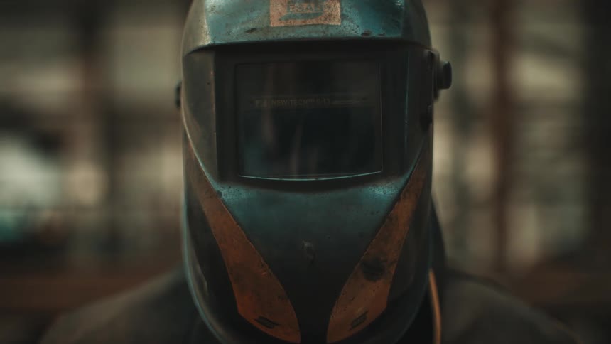 A welder is wearing a welders mask