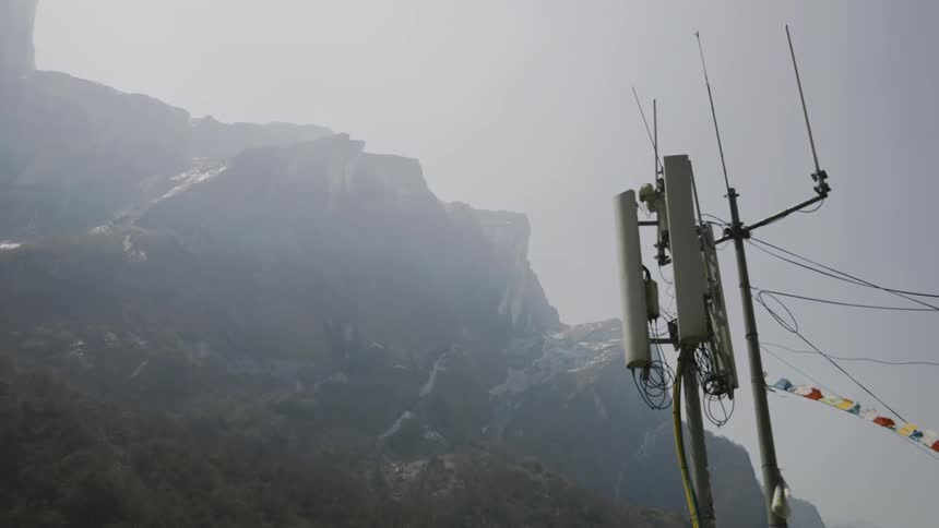 Antenna with wires in the foreground and mountains in the background