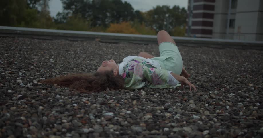 A woman is lying on a stone floor and she is crying