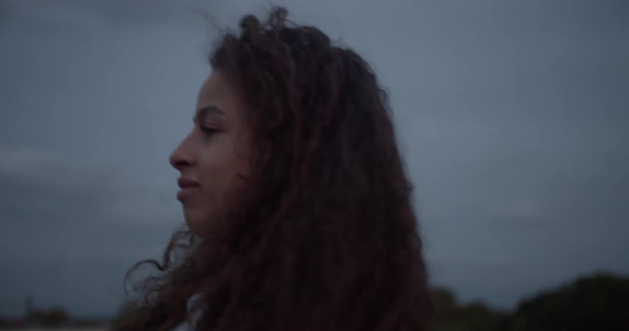 Side portrait of a curly haired woman walking