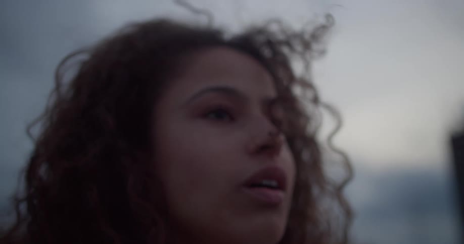 Portrait of a curlyhaired woman looking sideways in an outdoor setting