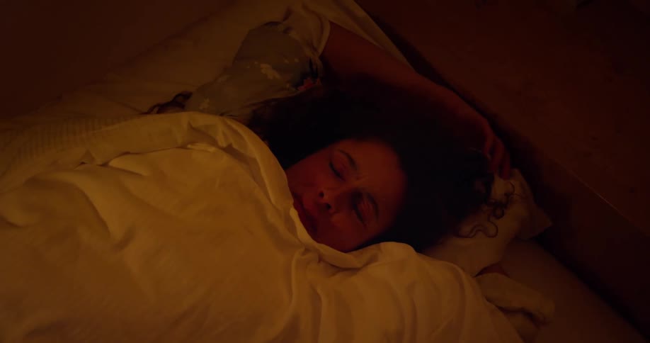 A woman wakes up in bed