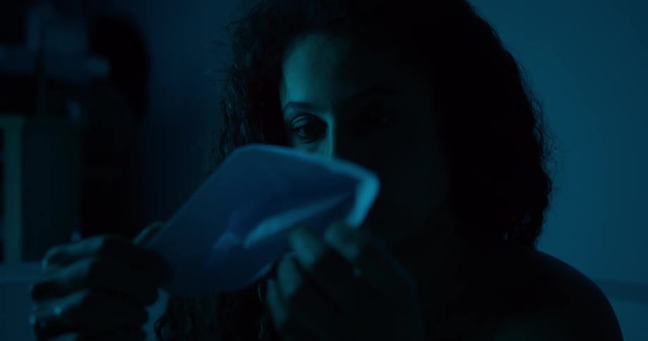 Portrait of a curlyhaired woman in a dark room in the redoxo on the boat made of paper