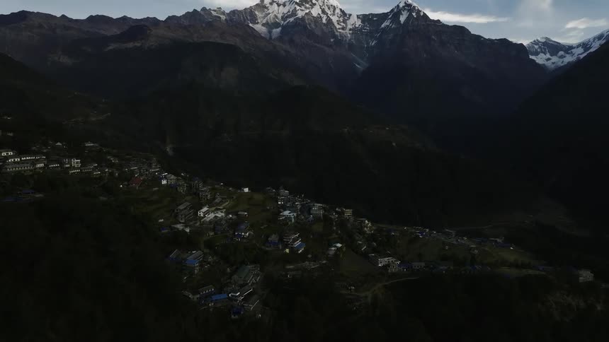 Aerial of a housing village that sits at the base of a mountain range