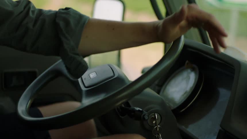 Hand of a person driving a vehicle and making a turn