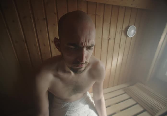 A man is sitting in the sauna