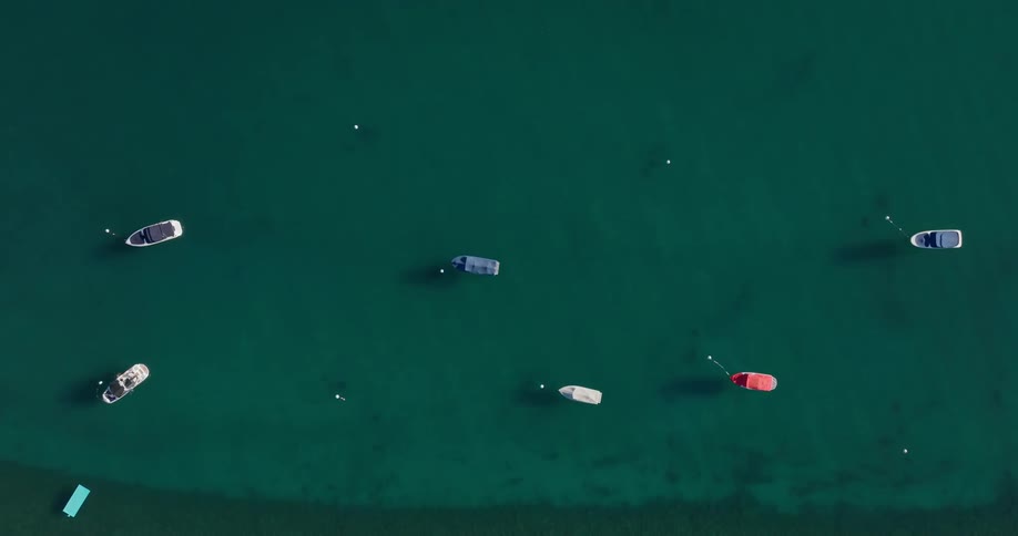 Aerial view of crystal clear water and stationary boats and yachts