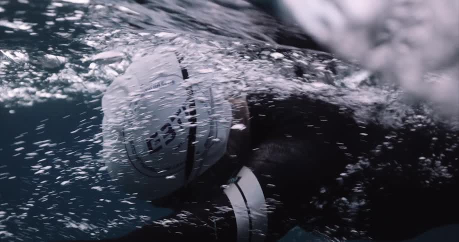 A woman swims through the water in slow motion