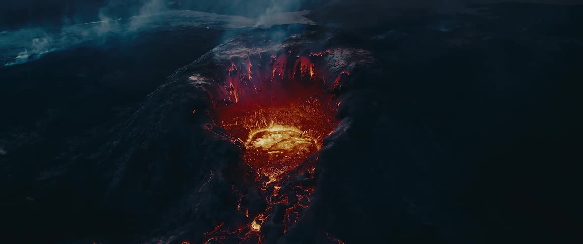 A volcanic eruption viewed from above sends molten lava cascading out of the crater