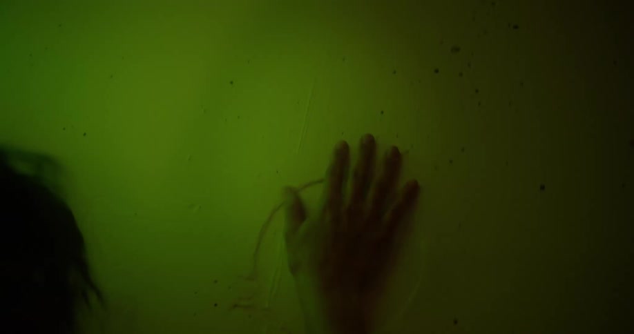 Woman slamming her hands against a metal door