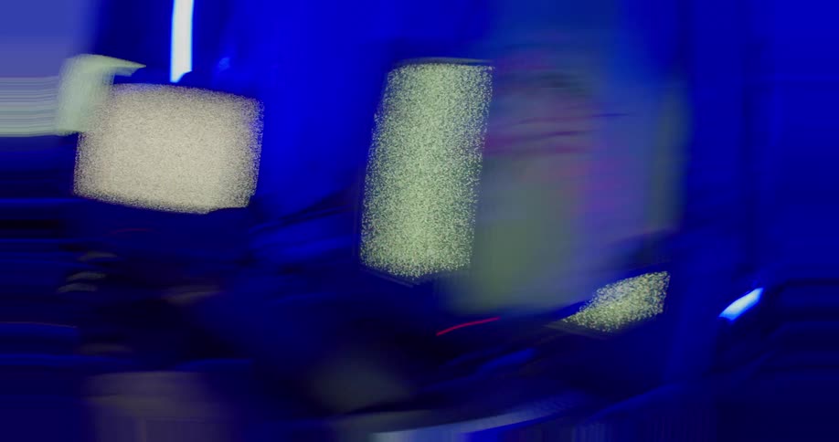 Woman with her back turned inside a room with blue electric lighting