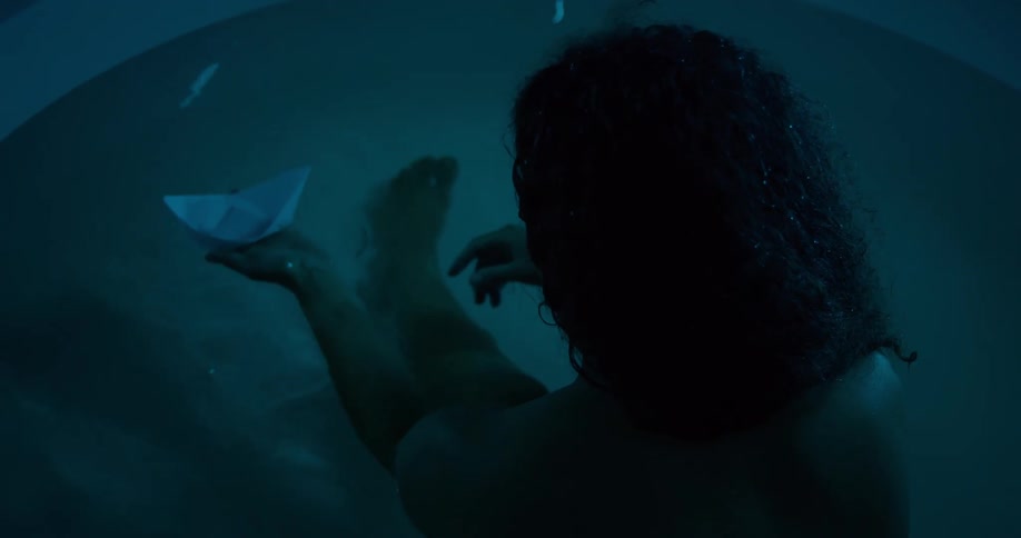 A woman floats a paper boat in the pool