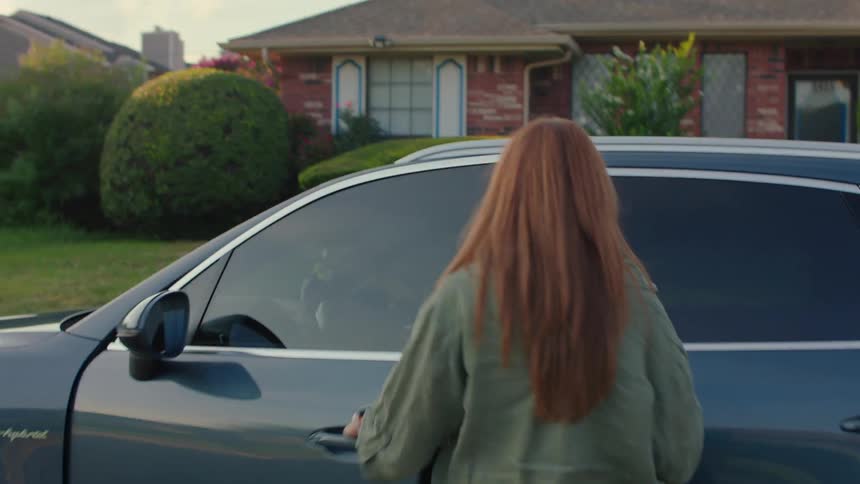 A woman walks to her car and gets in