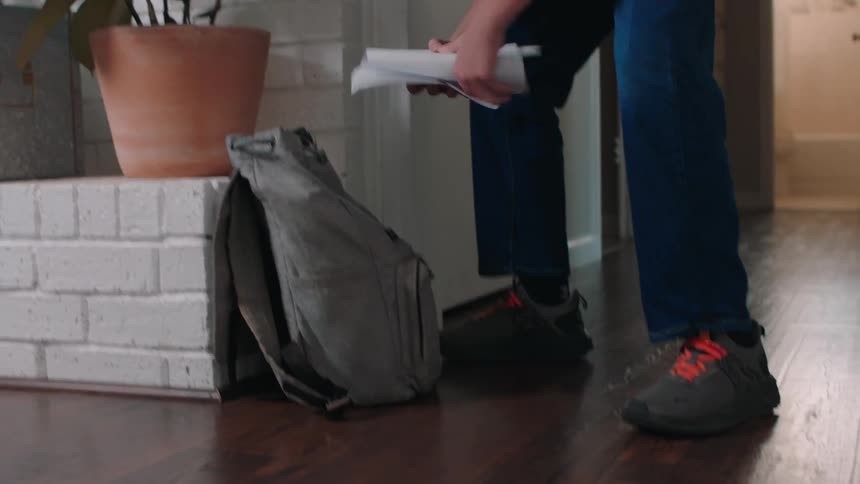A boy packs his backpack for school