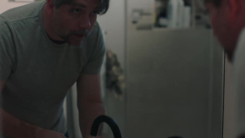 Man in front of mirror washing face in bathroom