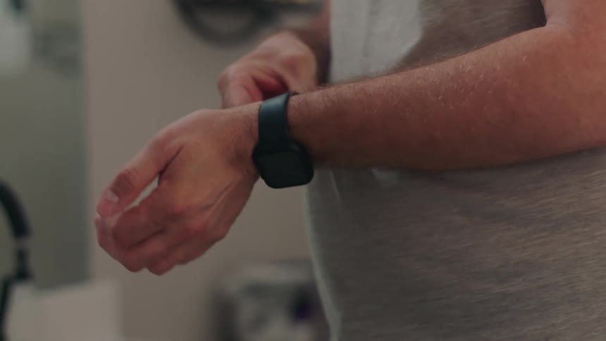 Man putting on a smartwatch and a ring