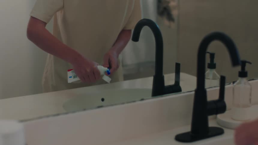 Boy in front of the mirror brushing his teeth in the bathroom