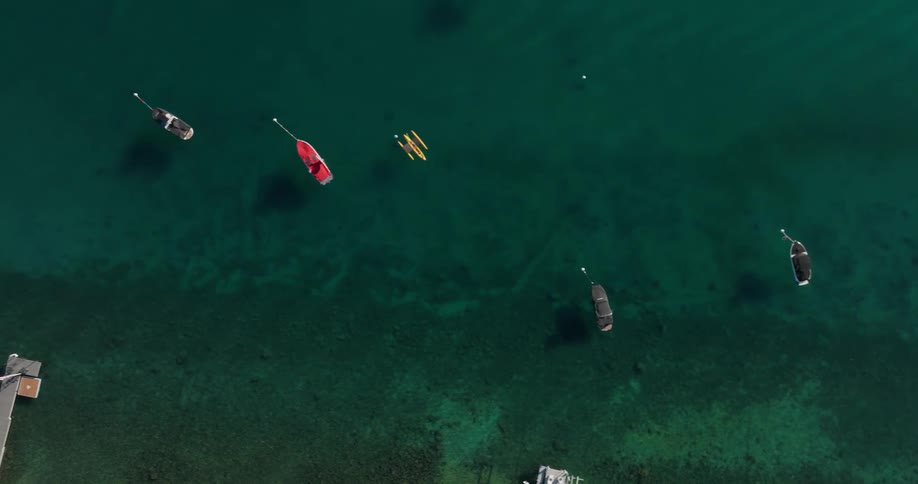 Aerial of multiple boats anchored on a large body of water