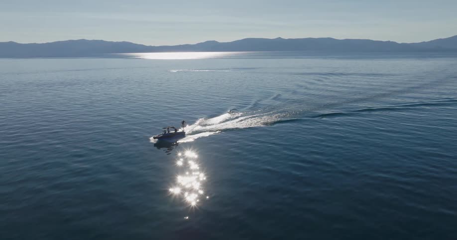 A group of people are boating and water skiing on a large lake