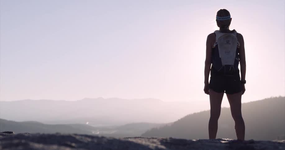 Back view of a runner standing on a mountain peak at sun rise near Donner Pass