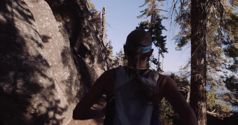 Back view of a woman running on a mountain trail near Lake Tahoe