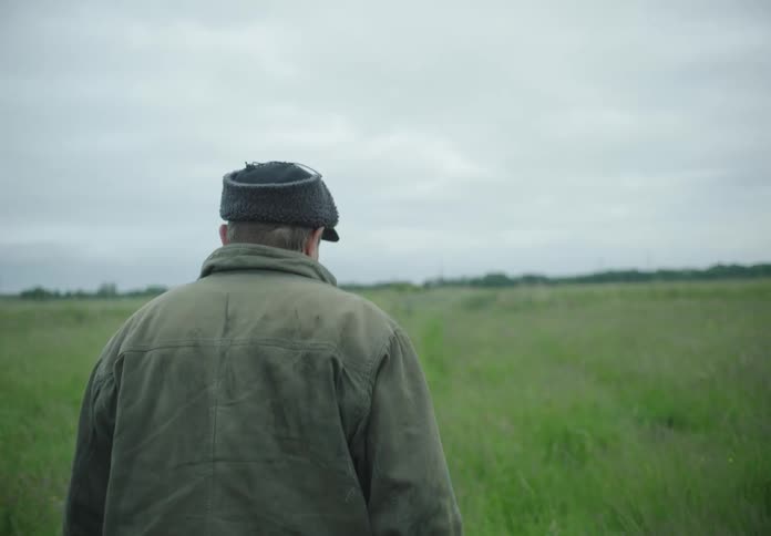 A man is walking in the tall grass