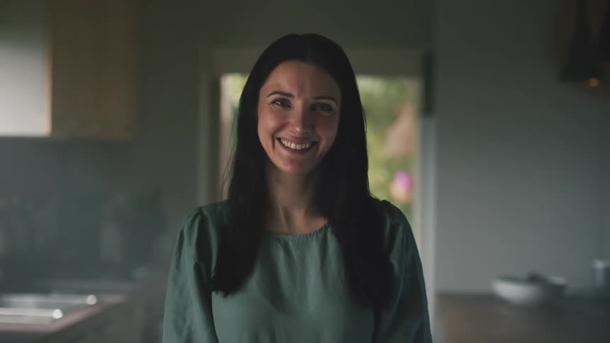Close up of the face of a young happy woman smiling while looking at the camera