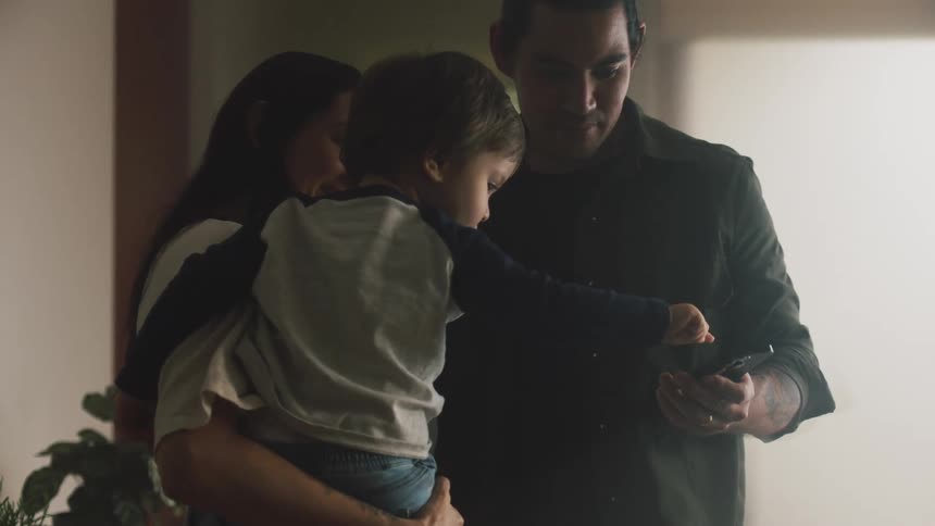 A young family is hanging out indoors in the middle of the day time