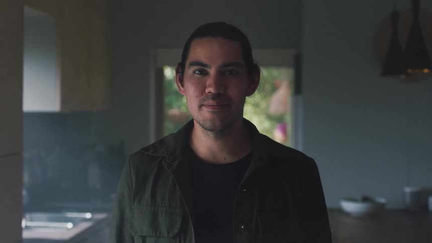 Portrait of a man standing in his kitchen and smiling