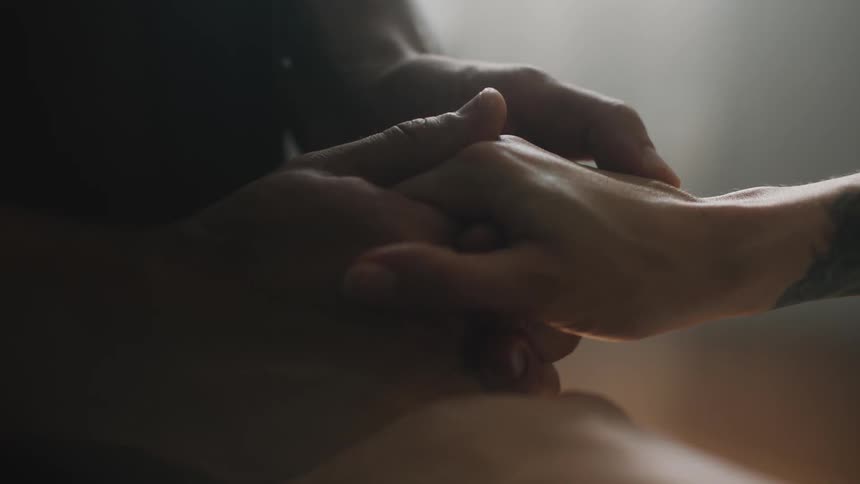Close up view of two people holding hands