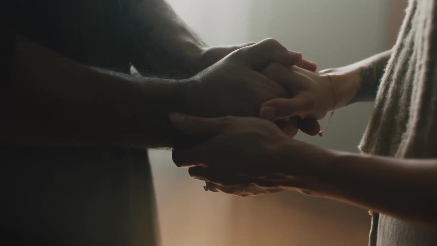 A close up of two people holding each others hands