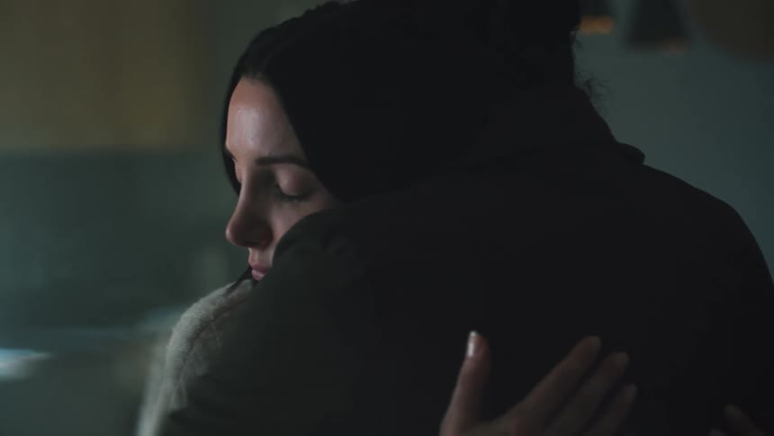 Woman looking sad at a man in front of her before they hug