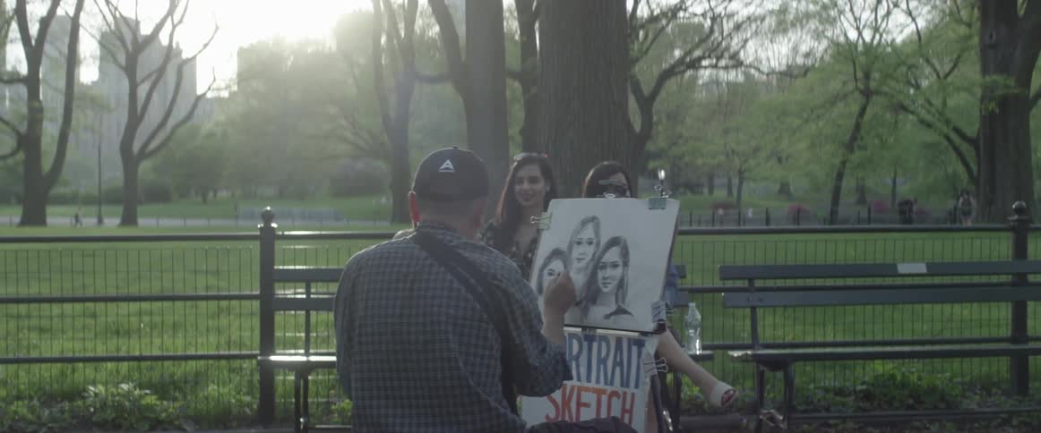 An artist paints caricatures of a group of women