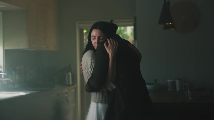 Husband and wife are hugging in their kitchen