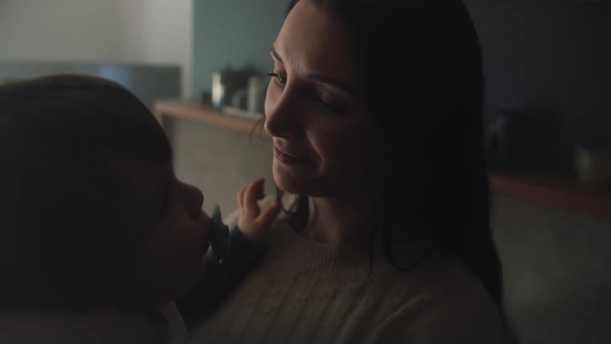 A woman holding a baby in her lap while theyre playing