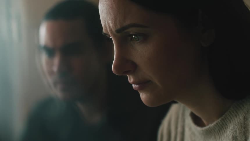 A woman and a man are sitting next to each other looking forward