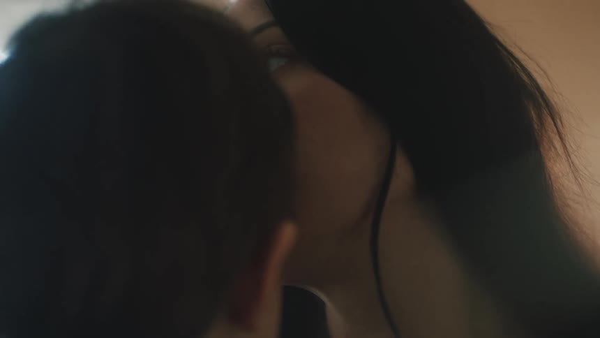 A woman kisses her son on the forehead