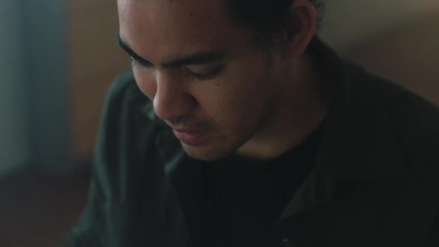 A man looks down while talking to someone