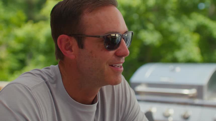 Portrait of a man with sunglasses sitting and talking