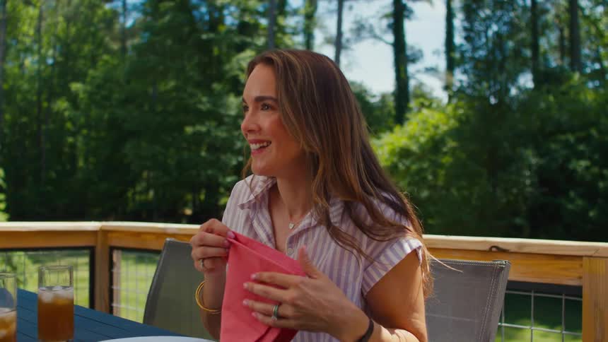 A woman picks up her handkerchief while eating