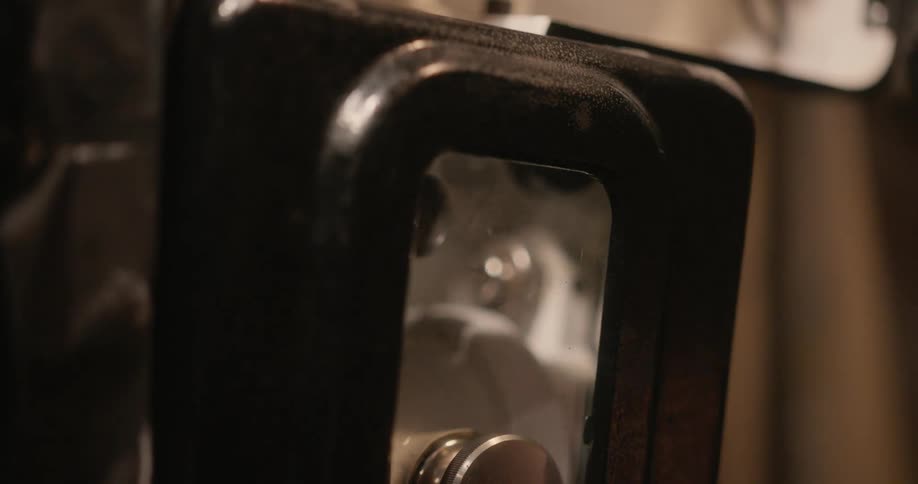Hand closing the door of a vintage film equipment