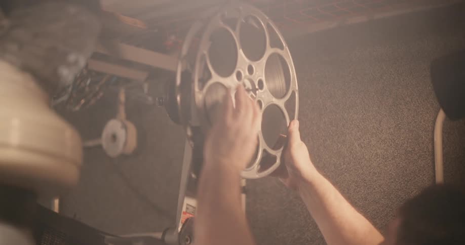 A man loads film in the projector