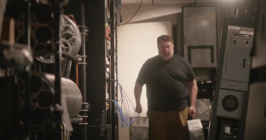 A person carries film canister through a room filled with cabinets