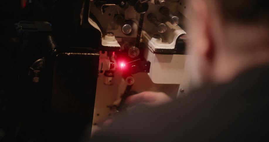 A person fiddling with a machine with a bright red led