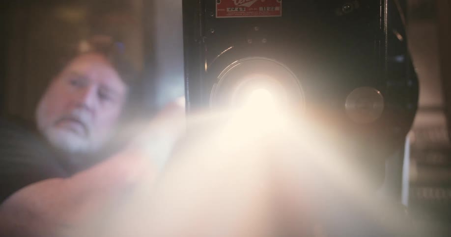 Man turning on an old movie player
