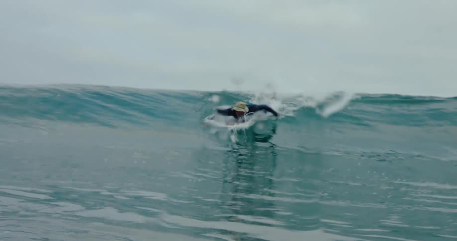 Man paddling to catch a wave and surf