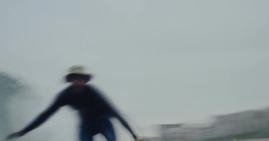 Man surfing a small wave in the sea on a cloudy day