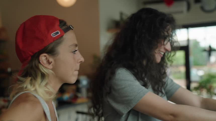 Two women in a studio with one of them holding a professional camera talking to each other