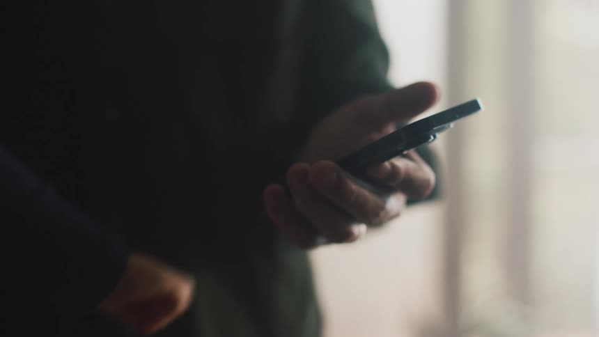 Small childs hand using a smartphone held by an adults hand