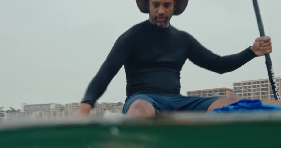 Man kayaking and collecting plastics from the sea